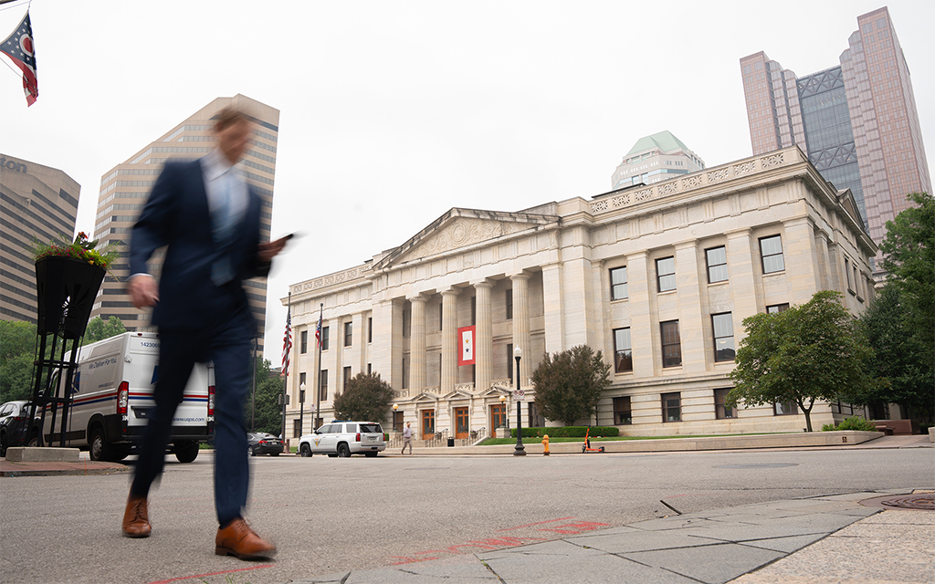 People walk by the Ohio Statehouse in Columbus on June 27, 2023. Other states are watching Ohio's dueling efforts to make it harder to pass amendments to the state constitution and to enshrine abortion rights in the constitution. (Photo by Mingson Lau/News21)