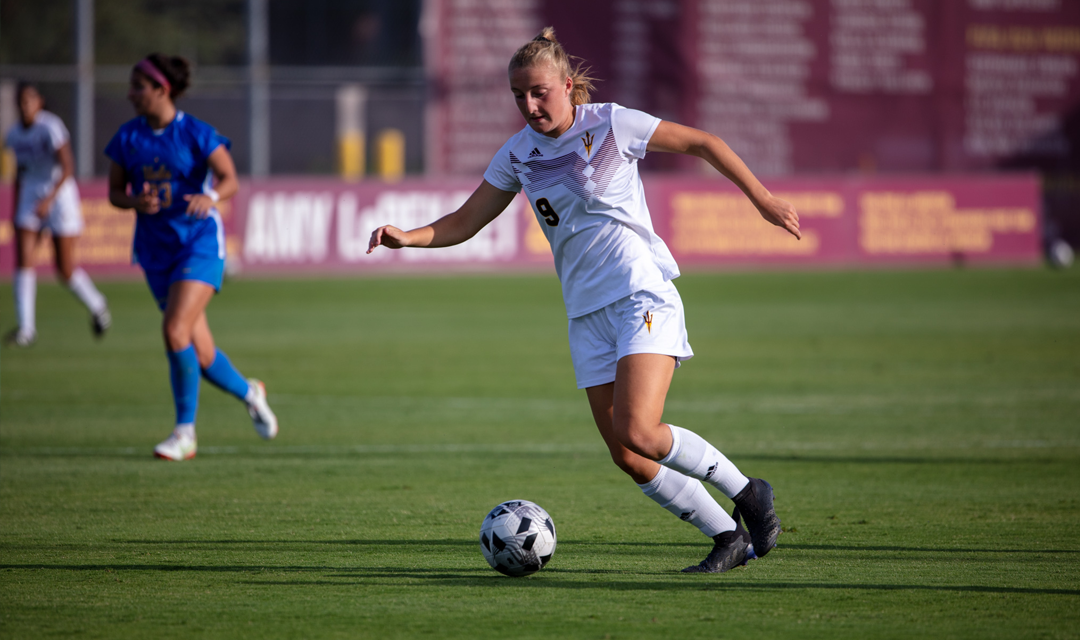 ASU Women's Soccer player dribbles a ball down the pitch