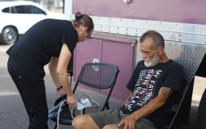 Medical coordinator Monica Rico prepares a blood pressure test for William Taft Cowan Jr. at the Circle the City mobile clinic in Phoenix on Sept. 12, 2023. (Photo by Sam Volante/Cronkite News)
