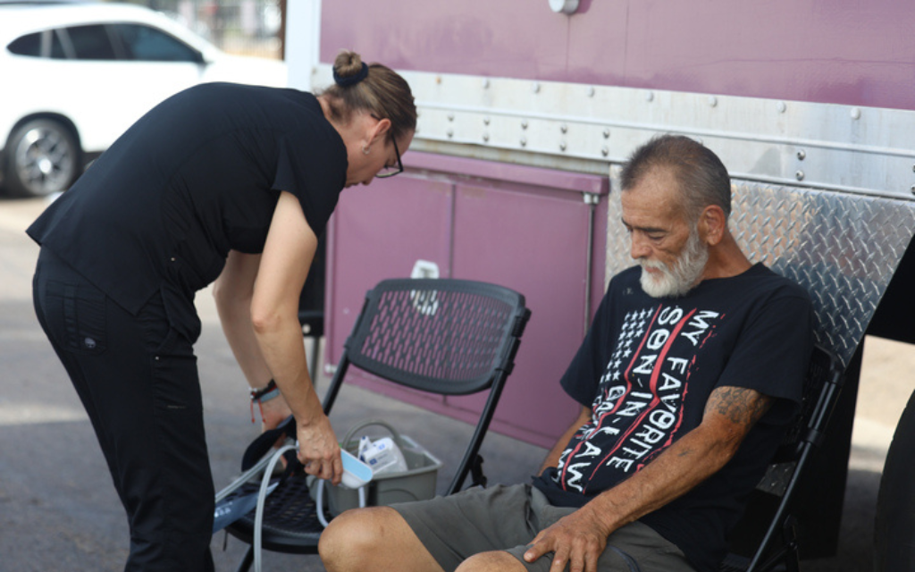 La coordinadora médica Mónica Rico prepara una prueba de presión arterial para William Taft Cowan Jr. en la clínica móvil de Circle the City en Phoenix el 12 de septiembre de 2023. (Foto por Sam Volante/Cronkite Noticias)