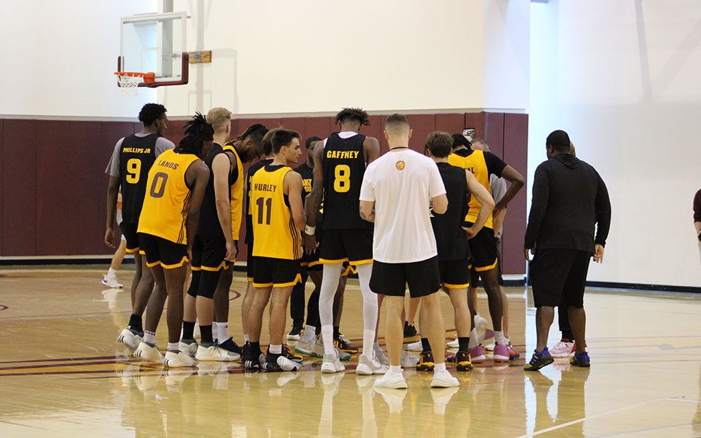 ASU basketball team huddled together.
