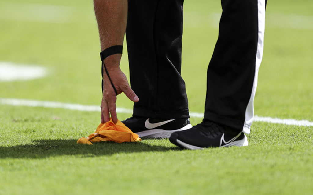 Referee grabbing flag off the field.