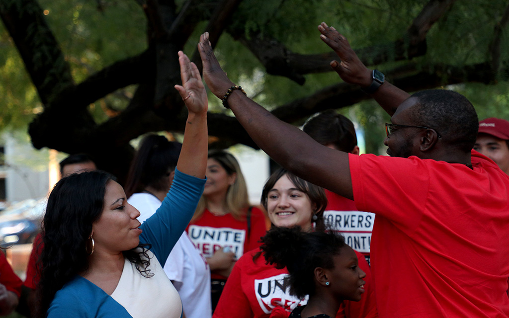 State Rep. Analise Ortiz, left, high-fives Michael Smith outside Phoenix City Hall on Sept. 6, 2023. Ortiz showed her support for Sky Harbor concession workers after they provided personal testimony at a city council meeting about low wages and tough working conditions. (Photo by Kevinjonah Paguio/Cronkite News)