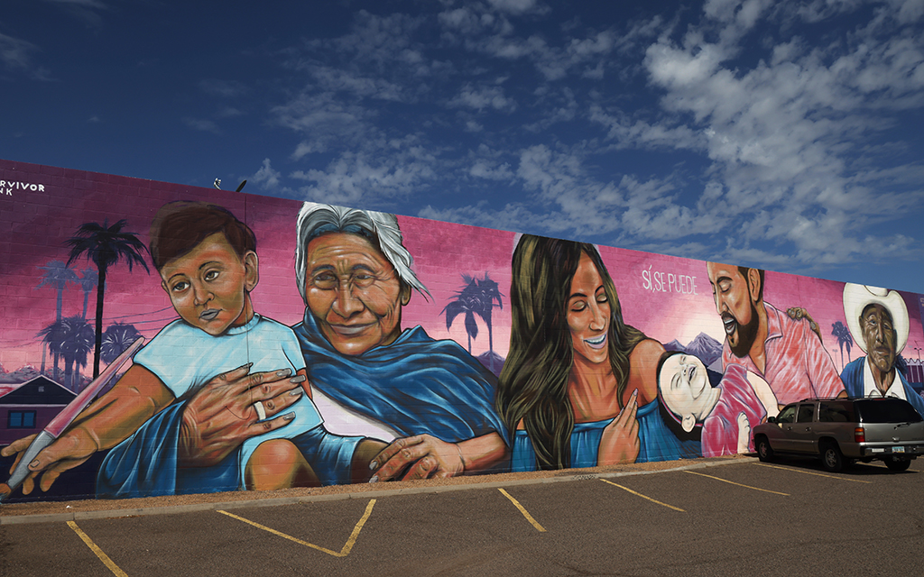 A mural of a Hispanic family emblazoned with the popular Spanish phrase “Sí, se puede,” welcomes visitors at Chicanos Por La Causa’s Centro de la Familia in Phoenix on September 13, 2023. (Photo by John Leos/Cronkite News)