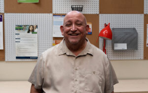 Richard Galindo, terapeuta en el Centro de la Familia de Chicanos Por La Causa, posa para un retrato en el vestíbulo del centro de servicios sociales. (Foto de John Leos/Cronkite Noticias)