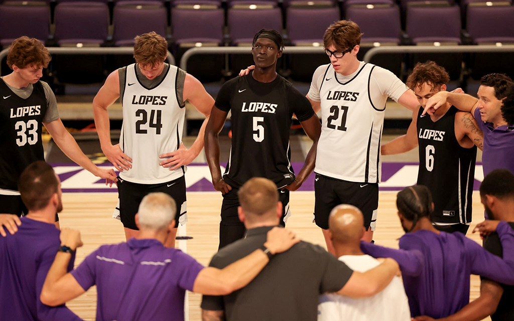 GCU Men's basketball in a team huddle.