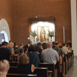 White carnations surround an altar of the Virgin Mary at Saints Simon and Jude Cathedral in Phoenix on Sept. 10, 2023. (Photo by Deanna Pistono/Cronkite News)