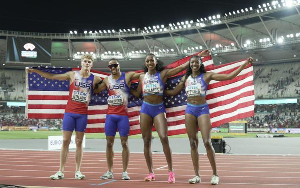 USA Track & Field team holding American flag.