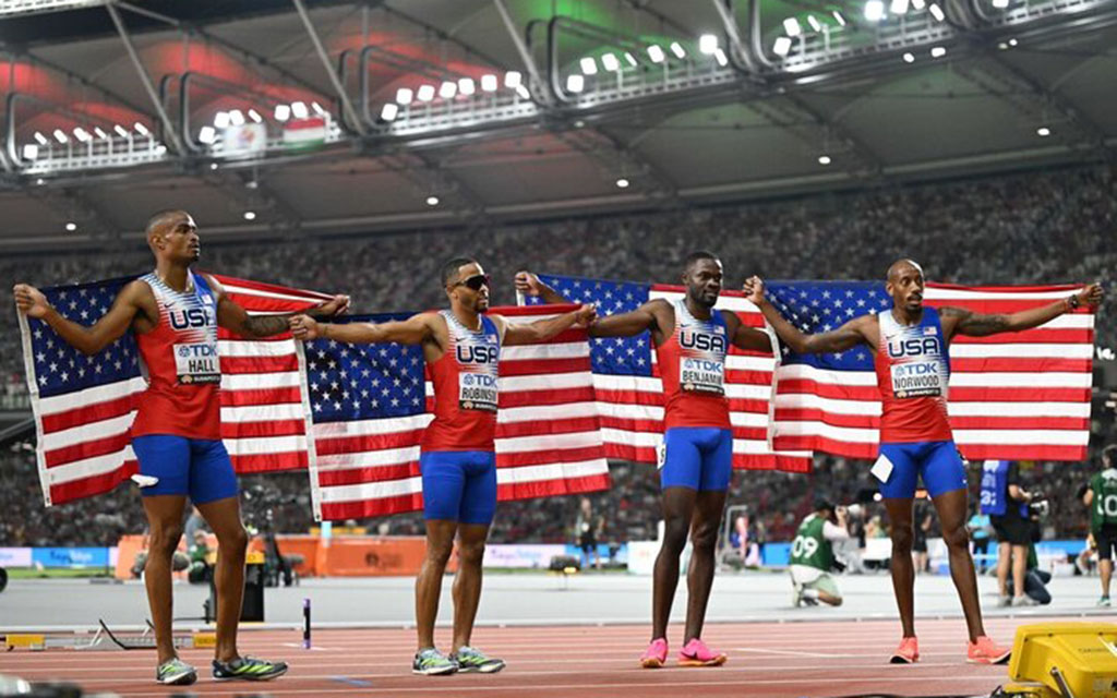 USA Track & Field team holding American flag.