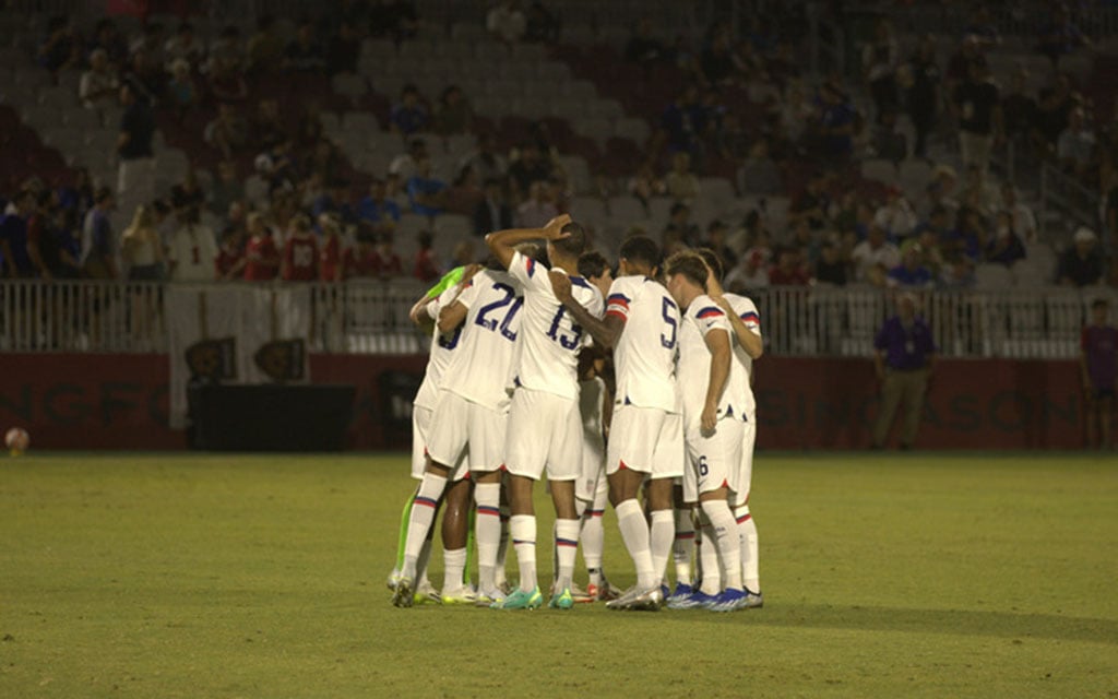 U-23 men's team huddled during a match.