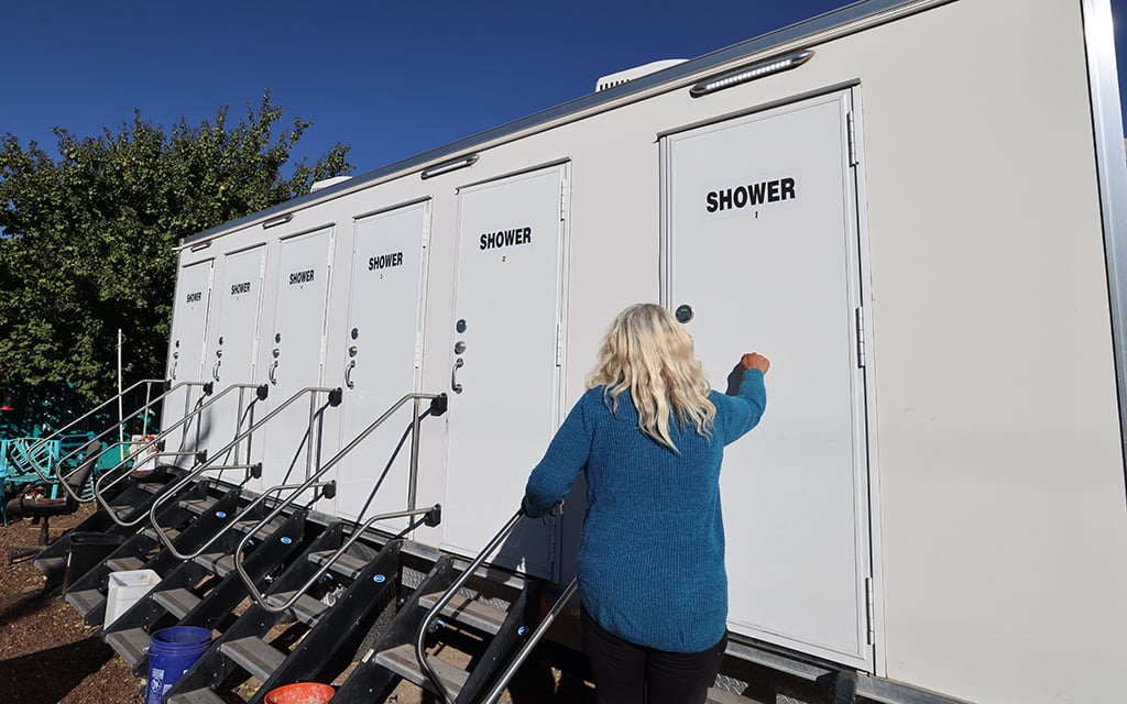 Pastor Joanne Landry shows the shower facility outside the Compassion Services Center in southeast Albuquerque, Oct. 30. (Photo by Caleb Scott/Cronkite News)