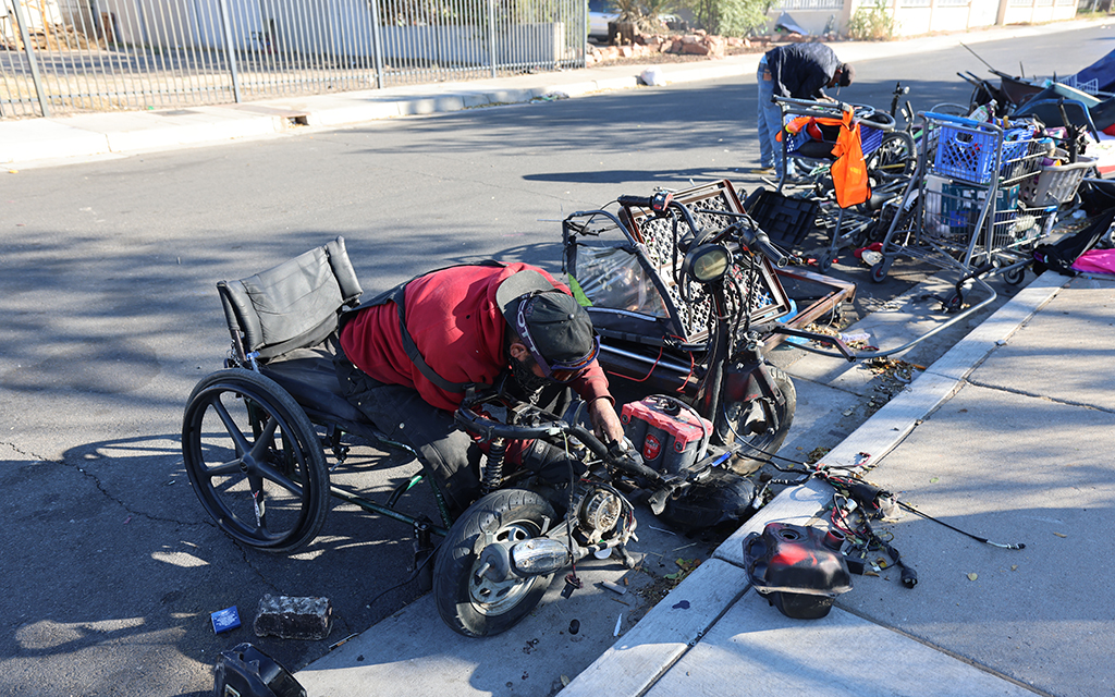 Rabbit builds custom bicycles on the street outside of the Compassion Services Center on Oct. 30. (Photo by Caleb Scott/Cronkite News)