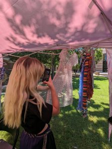 Rachel McComas snaps a photo of a dress to upload to her Depop account. “There’s so many clothes floating around that need a home,” she says. (Photo by Kate Duffy/Cronkite News)