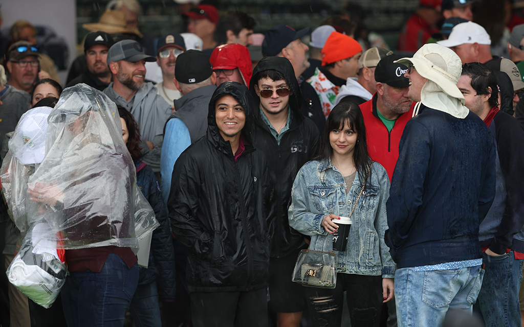 Fans huddle together as the rain turned to hail during Wednesday's celebrity pro-am at the WM Phoenix Open. (Photo by Alyssa Buruato/Cronkite News)