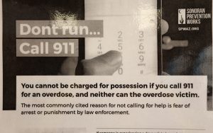 A poster in the lobby of Valle del Sol informs people that they can't be charged with possession of drugs when calling emergency services to report an overdose. (Photo by Jack Orleans/Cronkite News)