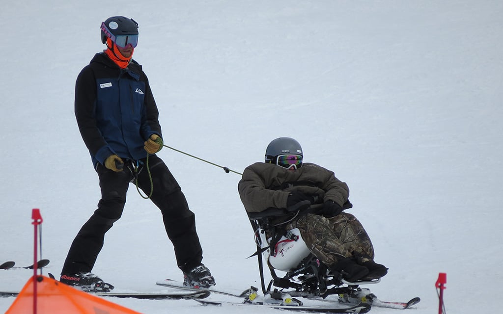 Mason Mogensen sits in adaptive ski equipment known as TetraSki with Truman Shoaff by his side. (Photo courtesy of High Country Adaptive Sports)