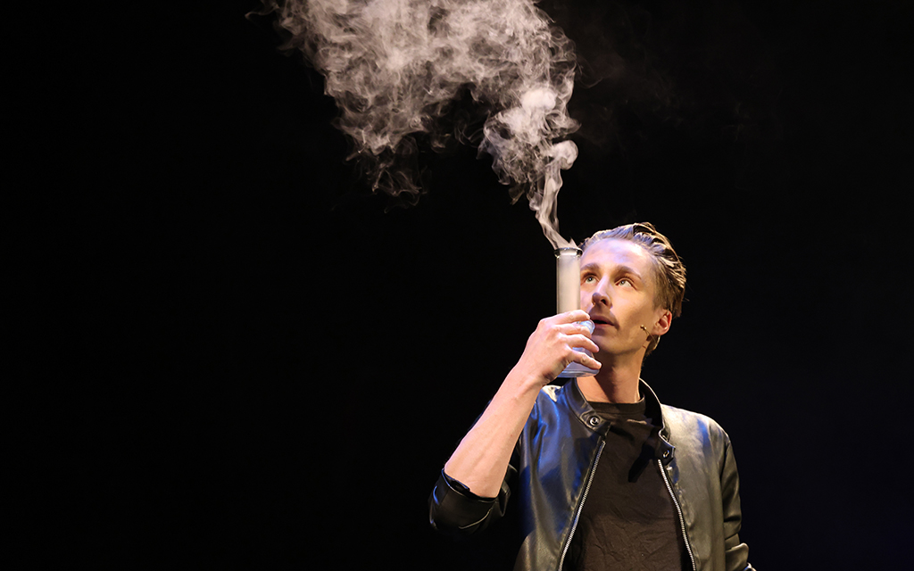 Ben Zabin smokes out of a bong at his cannabis-themed magic show, “Smokus Pocus,” on March 1, 2024, at Phoenix Center for the Arts’ Third Street Theater in Phoenix. (Photo by Marnie Jordan/Cronkite News)