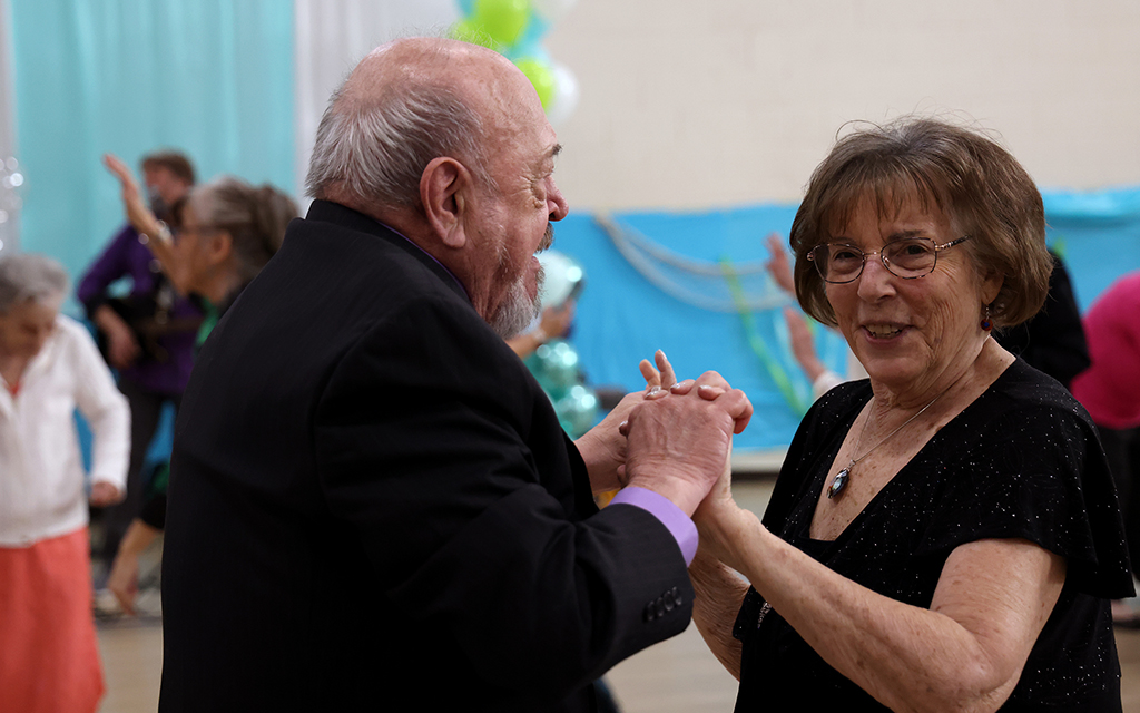 Elaine Galusha, right, dances with Bob Platek during a prom on Jan. 27. “These are vibrant-life communities,” said Kim Wood, director of wellness programming at Savanna House. (Photo by Kevinjonah Paguio/Cronkite News)