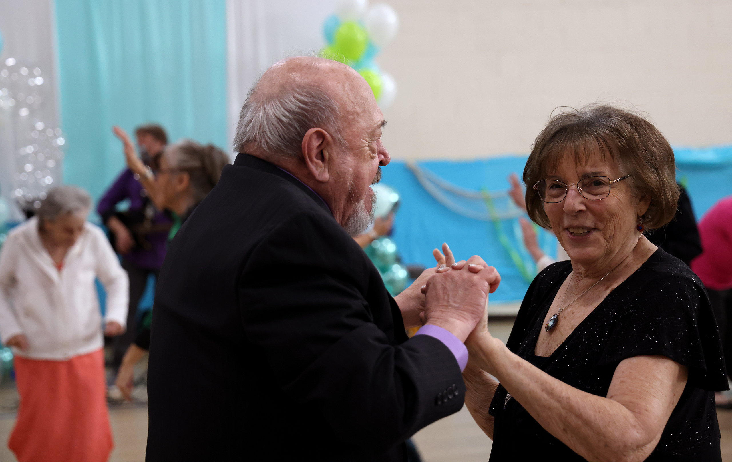 Elaine Galusha, right, dances with Bob Platek during a prom on Jan. 27. “These are vibrant-life communities,” said Kim Wood, director of wellness programming at Savanna House. (Photo by Kevinjonah Paguio/Cronkite News)
