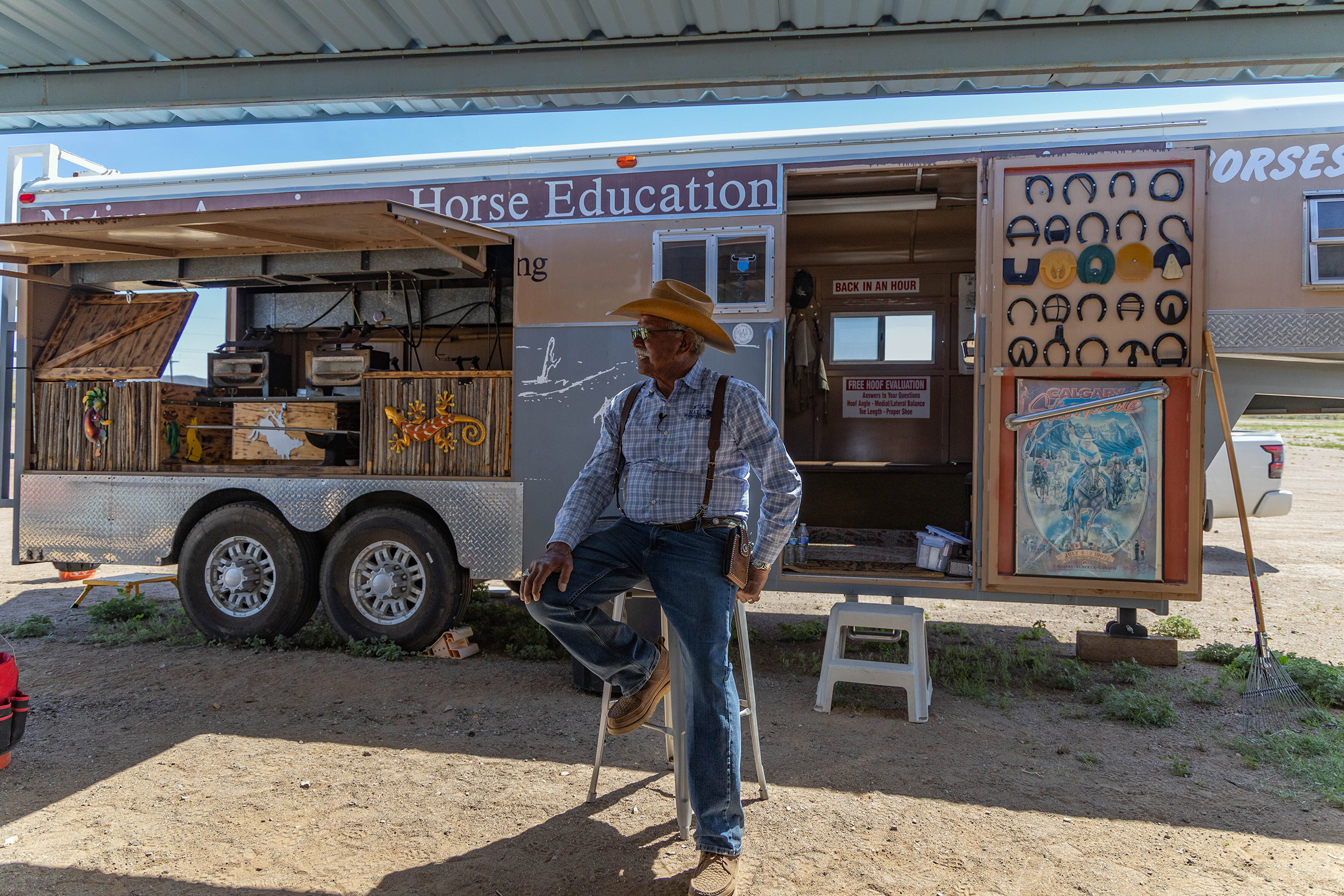 George Goode sits in front of his trailer on the Tohono O’odham Nation on April 10, 2024. Goode bought his trailer 30 years ago when the Native American Horse Education Foundation was still a dream. Now, he uses the trailer daily to help teach equine education to Native Americans. It houses materials necessary for horseshoeing, including burners, anvils, nails and shoes. (Photo by Sam Ballesteros/Cronkite News)
