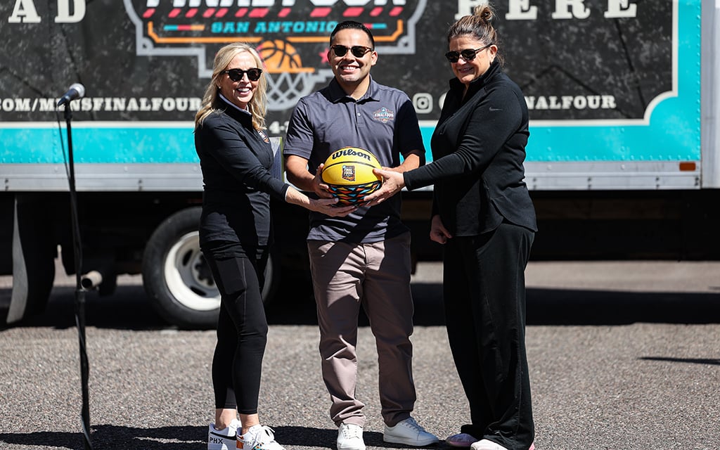 Manny Sanchez of the San Antonio planning committee receives the symbolic keys to the upcoming NCAA Men's Final Four event from Phoenix organizers JoAn Scott, right, and Jay Parry, left. (Photo by Ethan Briggs/Cronkite News)