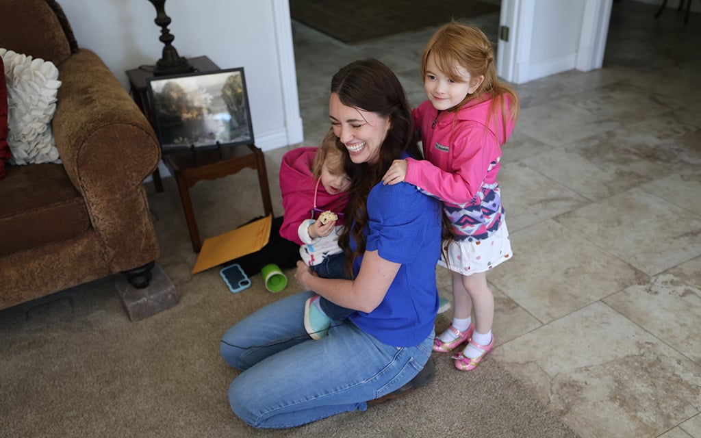 Carolyn Larsen embraces both of her kids on Feb. 15. (Photo by Jack Orleans/Cronkite News)