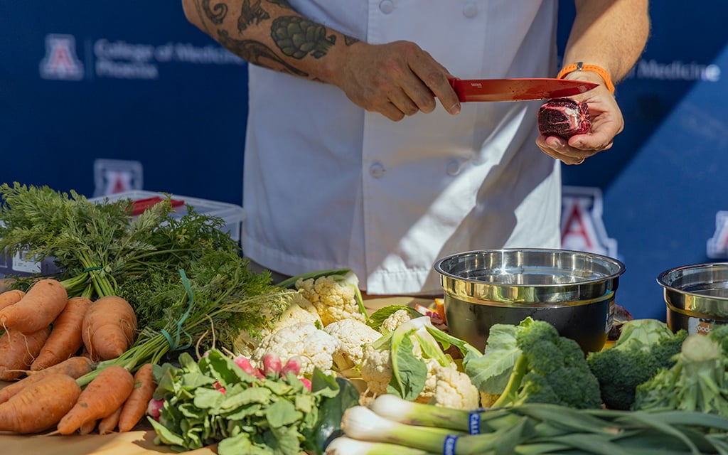 Chef Matthew Padilla, True Food Kitchen’s senior vice president of culinary, prepares fruits and vegetables for his cooking demonstration at the Health & Wellness Phoestival on April 13, 2024. (Photo by Sam Ballesteros/Cronkite News)