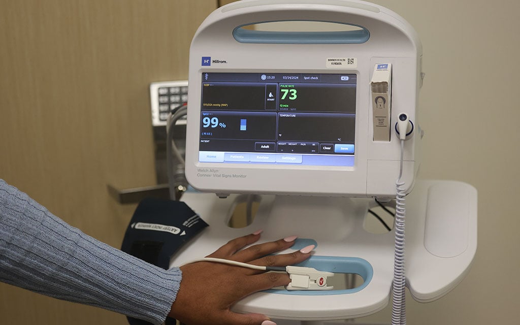 Meghan Dooley, spokesperson for Banner Health, puts her finger in a pulse oximeter machine on March 14. Multiple studies have shown that pulse oximeters may be less accurate with darker skin tones. (Photo by Jack Orleans/Cronkite News)