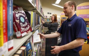 Samantha Mears, communications manager for the Maricopa County Library District, and Litchfield Park Library Manager Jeff Howick, place books on shelves at Litchfield Park Library on April 18, 2024. (Photo by Kayla Mae Jackson/Cronkite News)