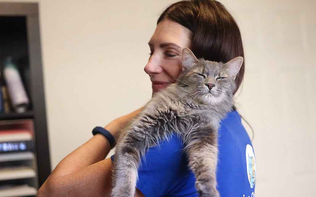 Kelly Stinson, volunteer at Saving One Life, cuddles one of her foster cats, Hank, on Feb. 28, 2024, in Chandler. (Photo by Mariah Temprendola/Cronkite News)