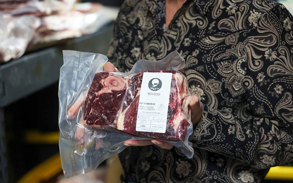 Lisa Khan, owner of Moon River Beef, holds up a package of broth bones on March 25, 2024. (Photo by Sam Ballesteros/Cronkite News)