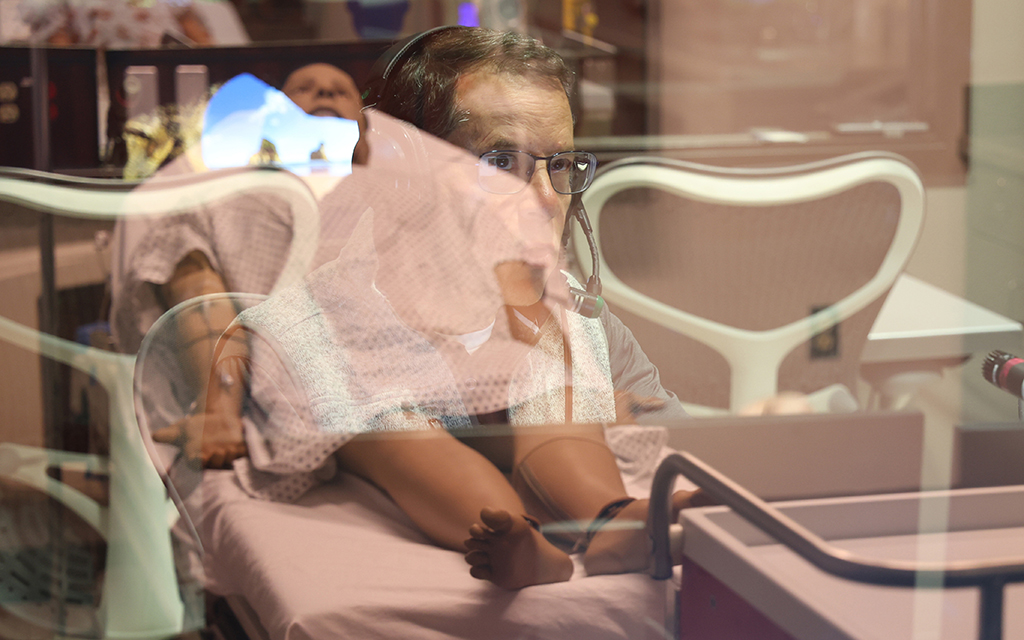 Brian Wilson, director de educación del Centro de Capacitación y Educación para la Simulación de la Salud, controla la simulación educativa desde una sala de control. (Foto de Jack Orleans/Cronkite Noticias)