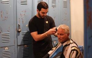 Robert Chayrez gets a haircut from Adriel Romano. Chayrez says he’s been coming to Justa Center for four years and has been able to get biweekly haircuts from volunteers. (Photo by Crystal N. Aguilar/Cronkite News)