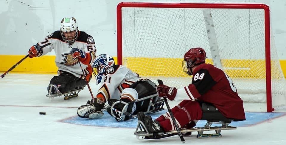 Joshua Gromer, right, executive director of Coyotes Sled Hockey, demonstrates his skills on the ice despite his physical challenges. (Photo courtesy of Joshua Gromer)
