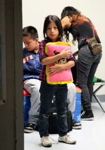 A young child clutches her pillow at a U.S. Customs and Border Protection facility. (Photo courtesy of Eduardo Perez/CBP)