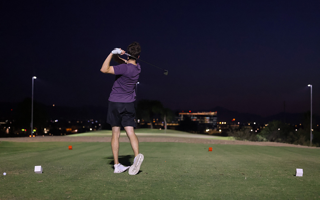 A golfer tees off under the lights at Arizona's first fully lit 18-hole golf course, operated by Grass Clippings Rolling Hills. (Photo by Grace Hand/Cronkite News)