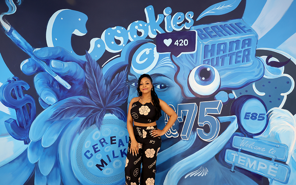 Alicia Deals poses for a portrait against the Cookies dispensary mural. Deals is one of the only Black women to own and operate a dispensary in Arizona. (Photo by Stella Subasic/Cronkite News)