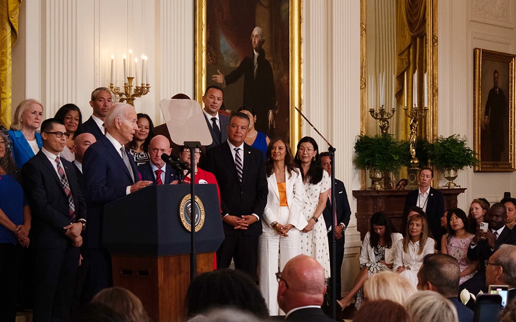 President Joe Biden addresses migrants and others in the East Room of the White House June 18, 2024. Sen. Mark Kelly, D-Ariz., stands to his left. (Photo by Benjamin Adelberg/Cronkite News)