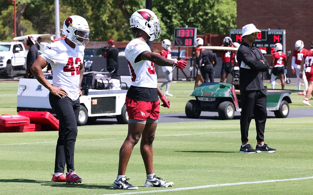 Cardinals safety Dadrion Taylor-Demerson, left, and wide receiver Xavier Weaver run drills despite the excessive heat warning and 109 degrees temperature. (Photo by Shirell Washington/Cronkite News)