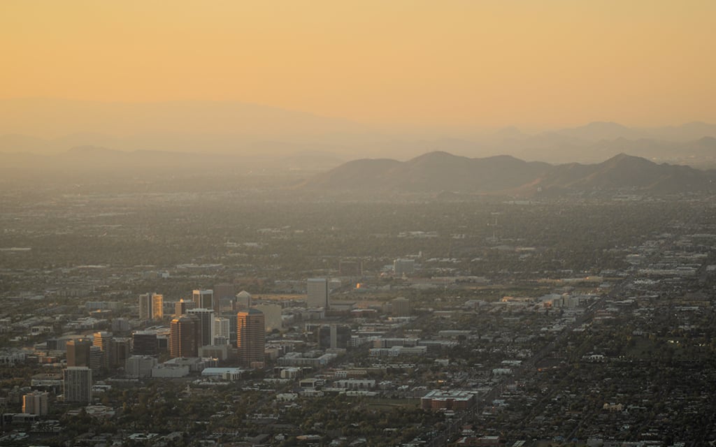 The sun sets over Phoenix on June 14, 2024. The city and its suburbs are attracting new residents and businesses despite shrinking water supplies. Local leaders say they have plans for expensive engineering projects that will help keep taps flowing for decades to come. (Photo by Alex Hager/KUNC)