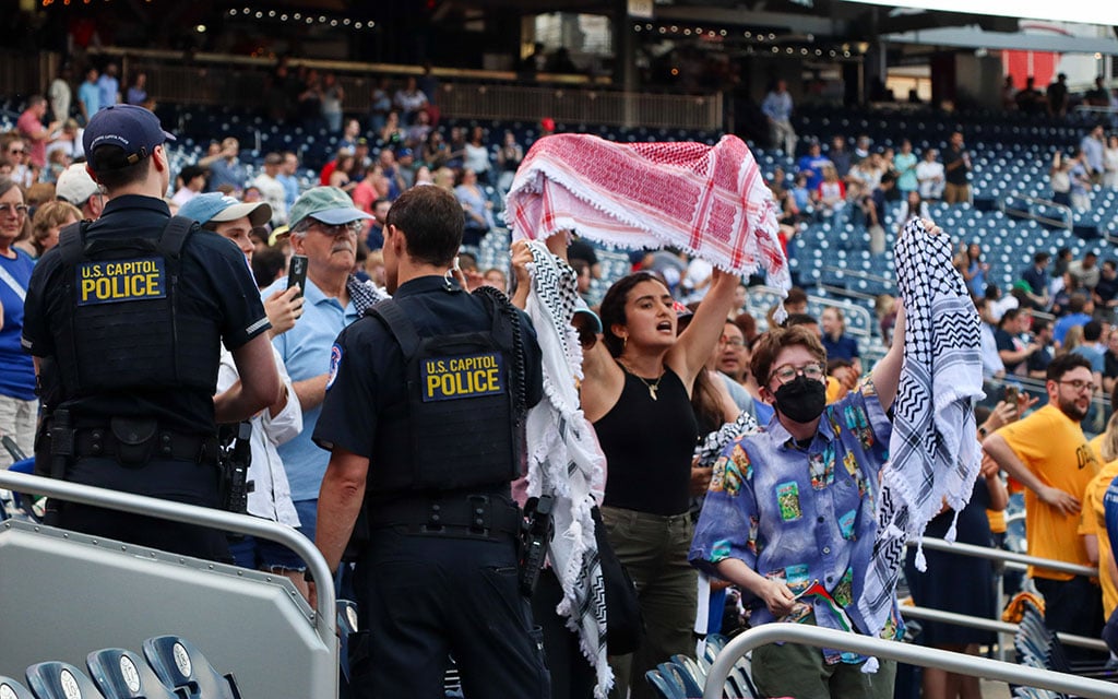 Capitol Police officers begin to escort pro-Palestinian protesters out of the Congressional Baseball Game at Nationals Park in Washington, D.C., on June 12, 2024. (Photo by Morgan Kubasko/Cronkite News)