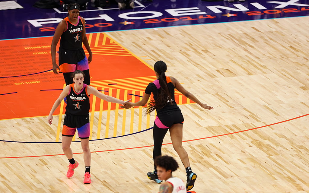 Caitlin Clark, left, and Angel Reese high-five after Clark dishes to Reese for her record-breaking 10th assist in Saturday's 2024 WNBA All-Star Game. (Photo by Grace Hand/Cronkite News)