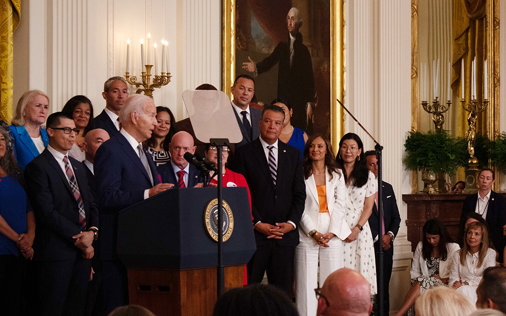 President Joe Biden addresses migrants and others in the East Room of the White House on June 18, 2024. Sen. Mark Kelly, D-Ariz., stands to his left. (Photo by Benjamin Adelberg/Cronkite News)