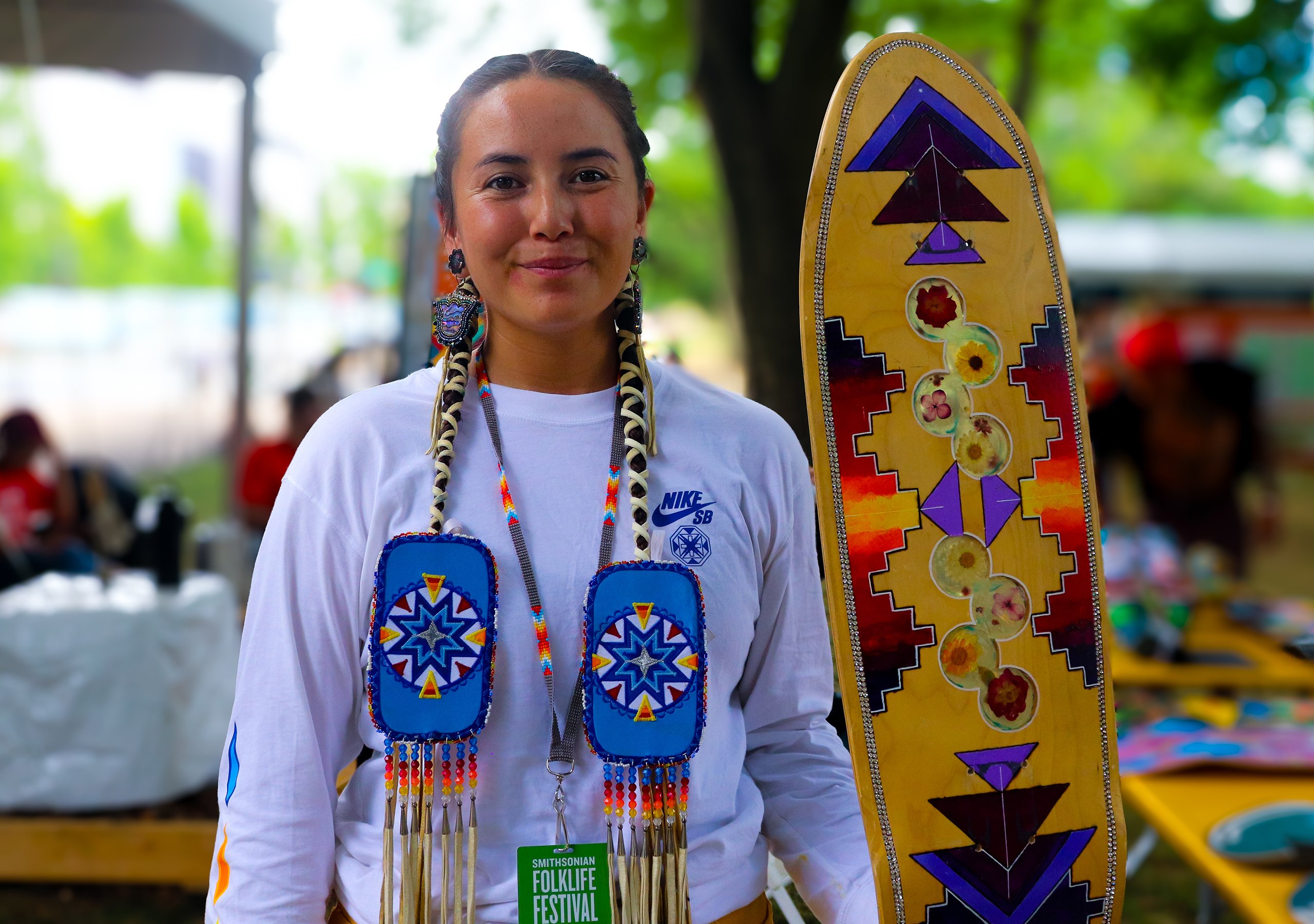 Di’Orr Greenwood with one of her handcrafted skateboards at the Smithsonian Folklife Festival in Washington, D.C., June 24, 2024. (Photo by Brianna Chappie/Cronkite News)
