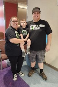 The Taylor family – from left Brittany, Jace, and Zachary – poses in Phoenix Children’s Hospital after Jace received the gene therapy. (Photo courtesy of Brittany Taylor)