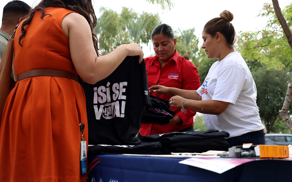 Jeamy Ramirez, left, and Edith Betancourt of Mi Familia Vota distribute free T-shirts at a National Voter Registration Day rally at the state Capitol in Phoenix on Sept. 20, 2022. The shirts read “¡Sí Se Vota!” (Yes, we vote!) and “Latino Loud.” (File photo by Alexia Faith/Cronkite News)