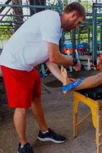 Dustin Williams, the co-head athletic trainer for the U.S. track and field team, showcases his skills as he discusses his experience at the University of Arizona and the vital role he plays at the Paris Olympics. (Photo by Savannah Bowie/Special for Cronkite News)