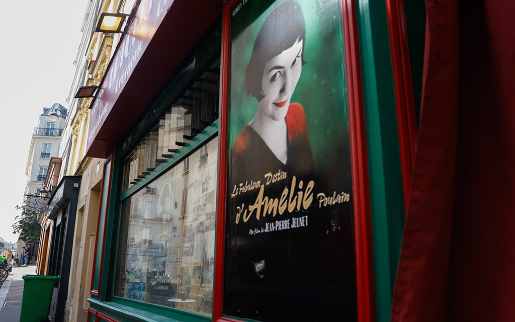 An Amélie poster is displayed on the side of Au Marche De La Butte, a famous landmark from the movie, in Paris. The city is popular with filmakers because of its beauty. (Photo by Sydney Lovan/Special for Cronkite News)