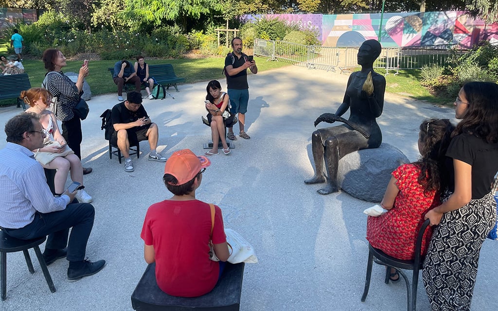 Passersby flock around the Olympic statue, "Salon," to stop and take pictures or sit in one of its six chairs. The statue sends a strong message about inclusivity. (Photo by Melanie Hogue/Cronkite News)