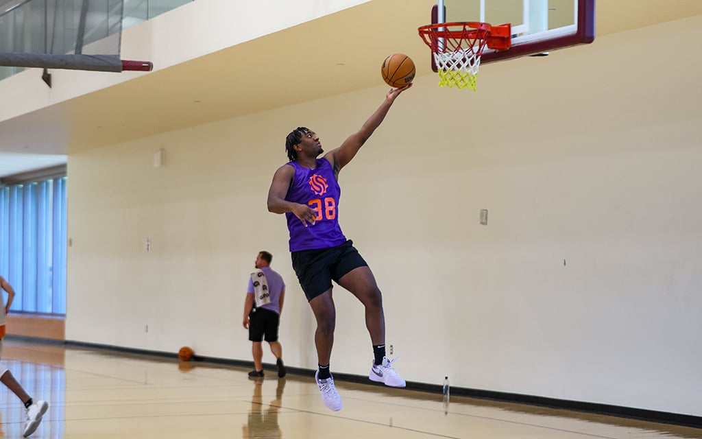 Kyree Walker in a purple jersey leaping for a layup at Sun Devil Fitness Complex.